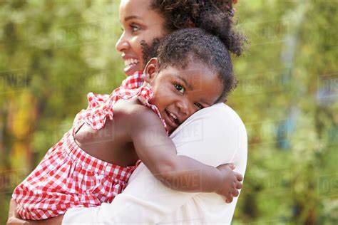 African American Mother Embracing With Baby Daughter Stock Photo