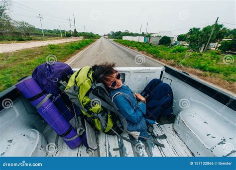 freedom backpacker girl with big backpack and travel hitchhiking growth in the back of a pickup