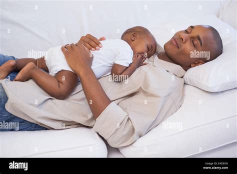 Happy Father Napping With Baby Son On Couch Stock Photo Alamy