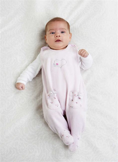 Female Baby Wearing Pink Rompers Lying On White Cloth Stock Photo