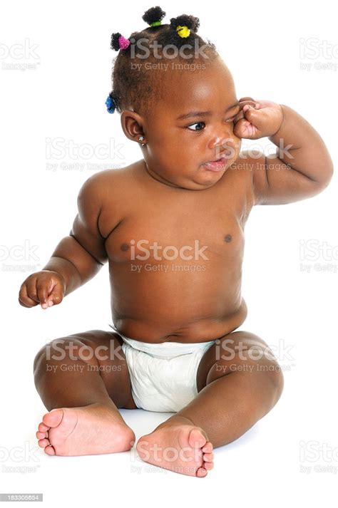 African American Baby Girl Sitting And Rubbing Her Eyes
