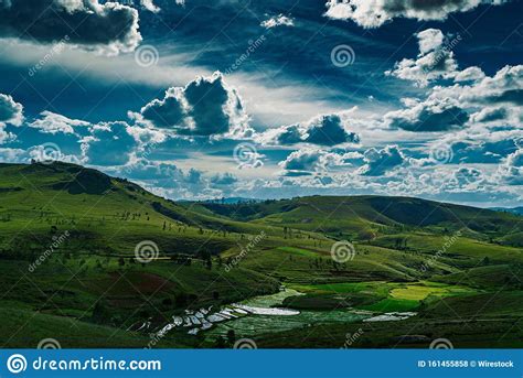 Beautiful Landscape Shot Of A Green Hill Valley With Thick Clouds In