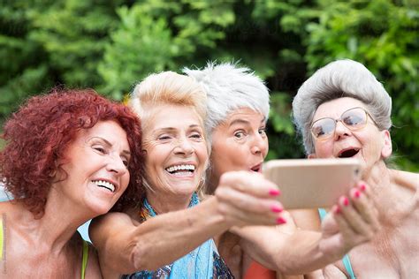 Four Mature Women Friends Taking A Selfie Outdoors By Stocksy