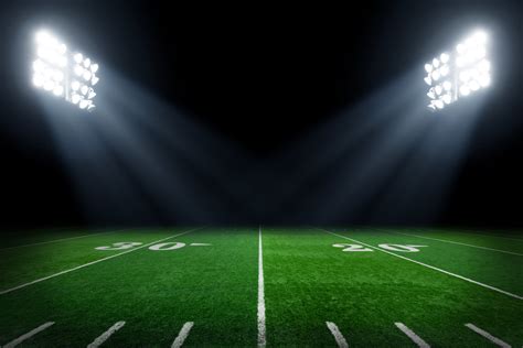 Football Field Illuminated By Stadium Lights