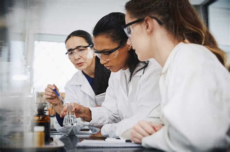 Female Chemistry Teacher Explaining To Young Multi Ethnic Students In