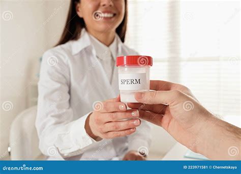 Donor Giving Container Of Sperm To Doctor In Hospital Stock Image