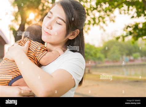 Asian 2 Months Baby Feeling Happy And Smiles With Her Mother In The