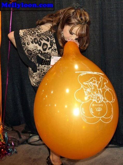 A Woman Holding An Orange Balloon With A Drawing On It