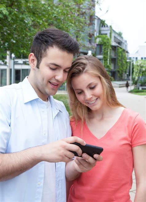 coppie che parlano del contenuto online in un telefono immagine stock immagine di consulto