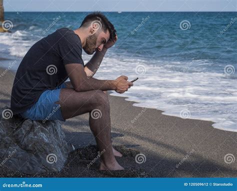 Young Man Sitting On A Beach Alone And Lonely Stock Photo Image Of
