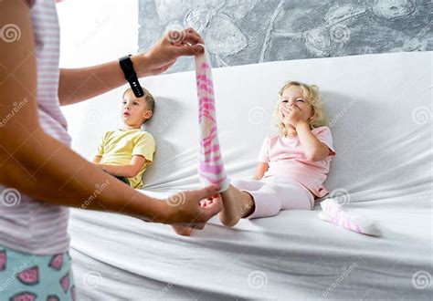 Mom Takes Off Her Little Daughter`s Socks And Tickles Her Feet A Little