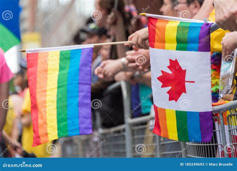 Gay Pride Parade Spectators Holding Canadian Gay Rainbow Flags During Toronto Pride Parade In