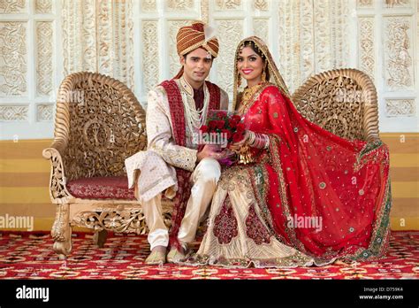 Indian Bride And Groom In Traditional Wedding Dress Sitting On A Stock