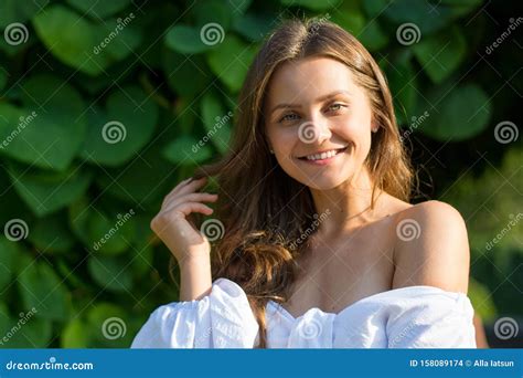 Jonge Mooie Vrouw Met Blote Schouders In Witte Kleren In De Tuin Stock