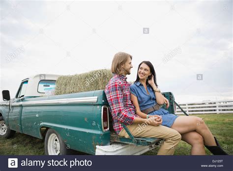 Couple Sitting On Tailgate Of Pick Up Truck Stock Photo Alamy