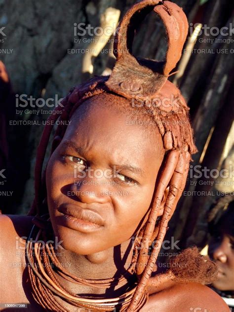 Portrait Of A Nomadic Himba Woman Sitting In Front Of Her Hut Stock