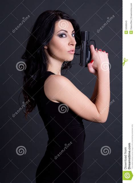 Portrait Of Woman Secret Agent Posing With Gun Over Grey Stock Image