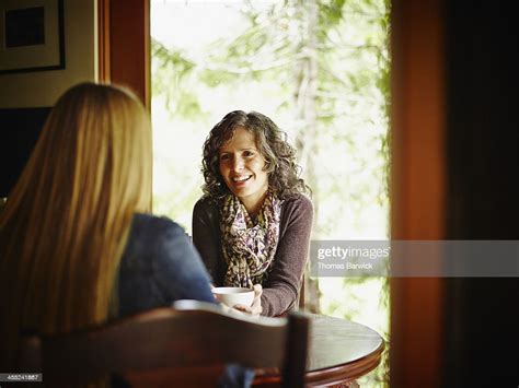 Two Mature Women Sitting At Kitchen Table In Cabin Bildbanksbilder