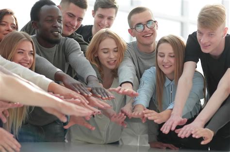 Premium Photo Group Of Smiling Young People Joining Their Hands
