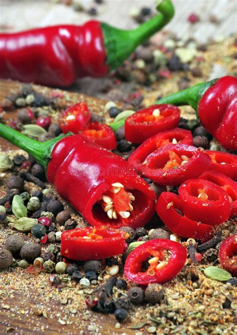 Red Hot Chili Peppers And A Mixture Of Different Peppers On A Wooden
