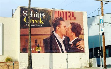 Schitts Creek Advertises Final Season With Same Sex Kiss On Billboard