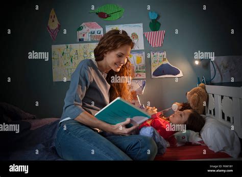 Mother Reading A Bedtime Story For Her Little Daughter Stock Photo Alamy