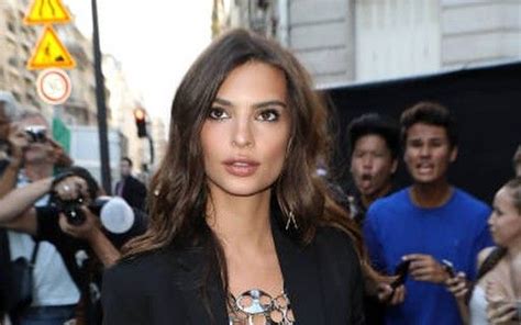 A Woman Standing In Front Of A Group Of People On The Street With Cameras Around Her