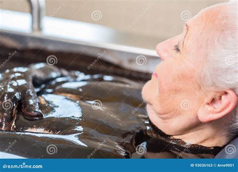 donna senior che gode della terapia di alternativa del bagno di fango immagine stock immagine