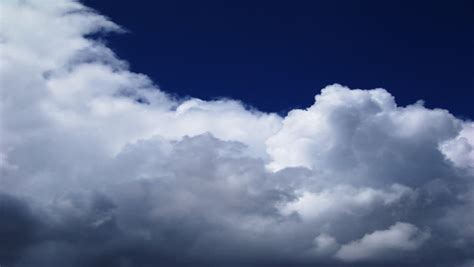 An Hd Time Lapse Of Clouds Against A Dark Blue Sky Stock Footage Video