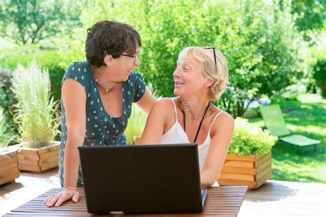 Two Mature Women Friends Using Laptop On The Garden Terrace Stock Image Image Of Smile