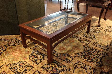 The coffee table offers benefits for your decoration. Lot - A mahogany glass topped coffee table.