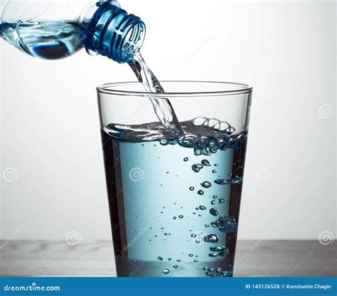 Pouring Water From Bottle Into Glass Stock Photo Image Of White Blue