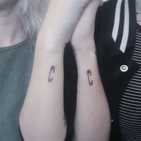 Two Women With Matching Tattoos On Their Arms One Holding The Others Hand