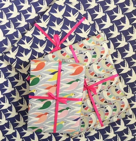 Two Wrapped T Boxes With Pink Ribbons And Birds In The Background On