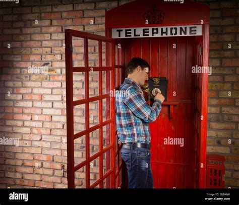 Man Standing Making A Call In A Red British Telephone Booth With A