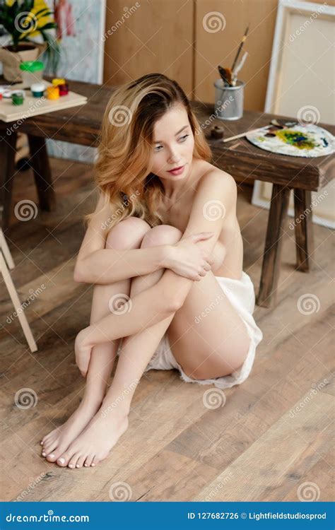 High Angle View Of Beautiful Sensual Naked Artist Sitting And Looking Away Stock Photo Image