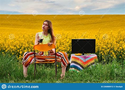 Girl Sitting On A Chair With A Drink In The Field Stock Photo Image