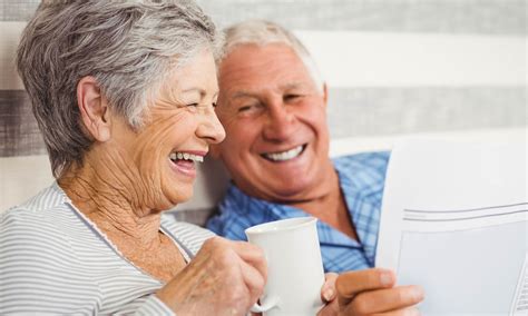 Older Couple Laughing In Bed Pastime Club