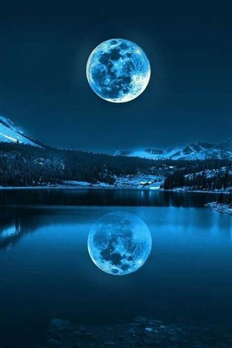 The Full Moon Is Reflected In The Still Waters Of A Mountain Lake With