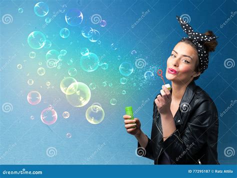 Pretty Lady Blowing Colorful Bubbles On Blue Background Stock Image