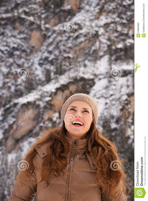 Smiling Woman Outdoors Among Snow Capped Mountains Looking Up Stock