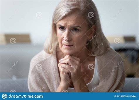 Worried Mature Woman Feel Concerned About Health Problems At Home Stock