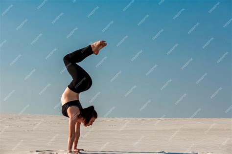 Premium Photo Young Woman Practicing Handstand On Beach With White