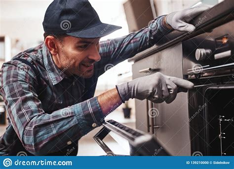 Don`t Delay With Repair Close Up Of Repairman Examining Oven Stock