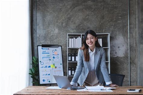 Portrait Confident Asian Business Woman Standing At Her Desk On Office