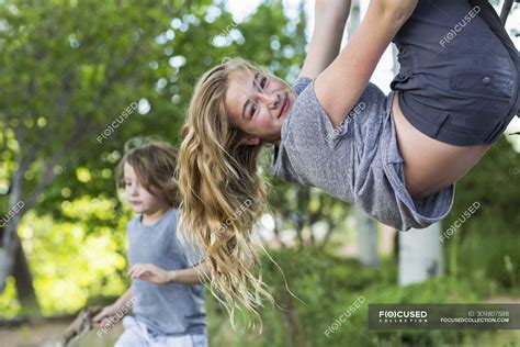 Blonde Teenage Girl Hanging Upside Down From Tree In Garden — Summer Looking In Camera Stock