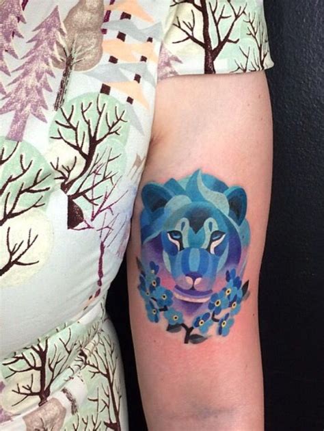 A Womans Arm With A Blue Tiger Tattoo On It