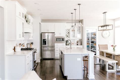 A Large Kitchen With White Cabinets And Stainless Steel Appliances