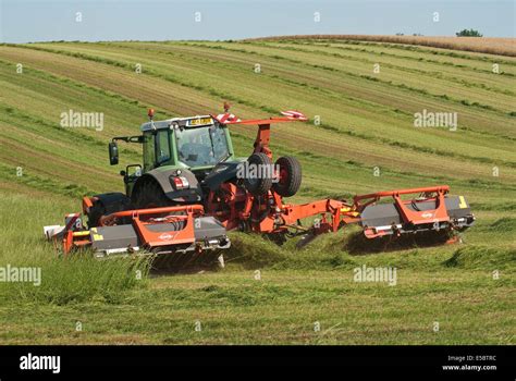 Tractor Pulling Grass Cutter Cutting Grass For Making Hay Stock Photo