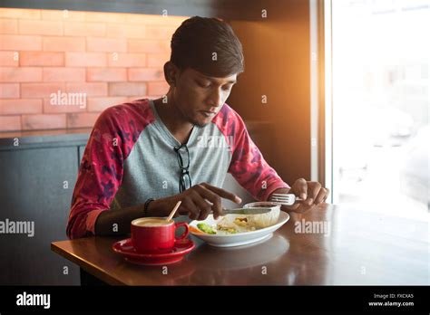 Teenage Indian Male Eating At Cafe Stock Photo Alamy